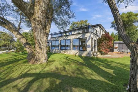 Covered lakeside porch with outdoor seating at 3 Willowbank Avenue